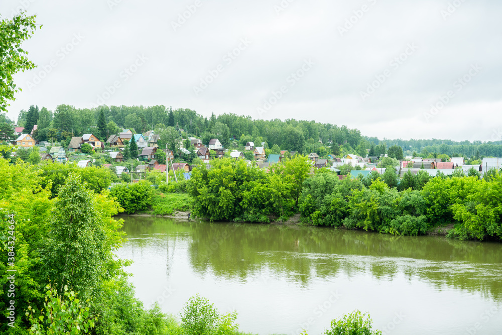 View on the valley with village, river and forest. Summer landscape.