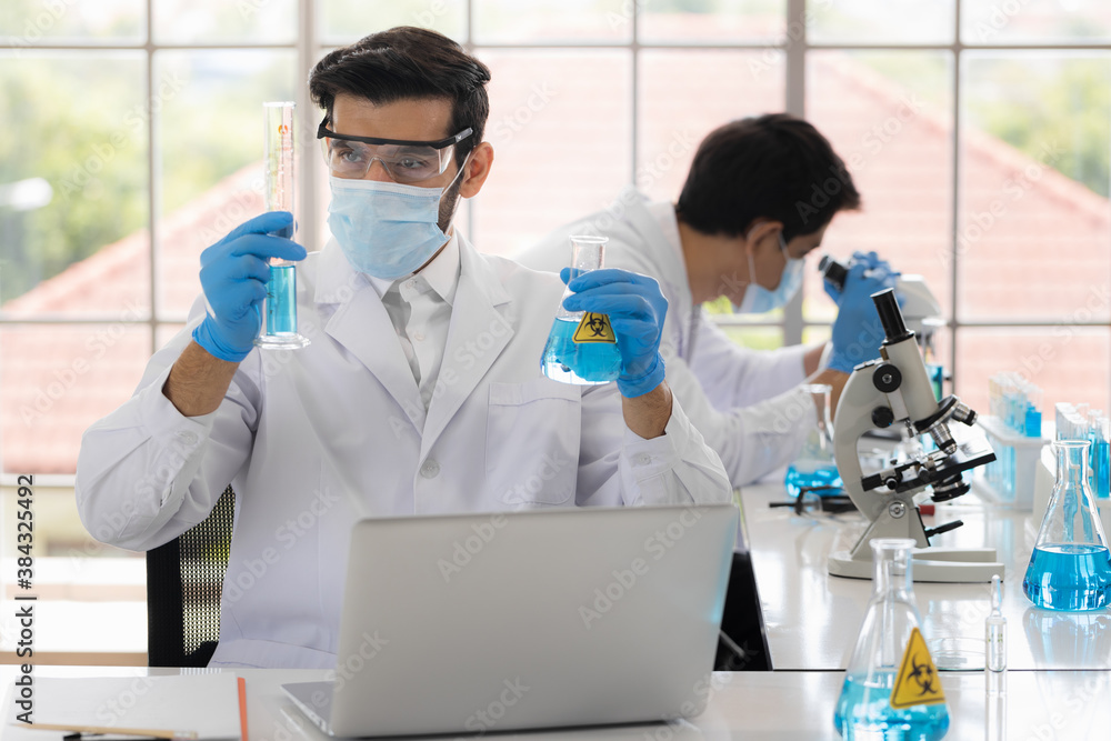 Health care researchers working in life science laboratory. Male research scientist and supervisor preparing and analyzing in research lab. Invention of the coronavirus vaccine Health care researchers working in life science laboratory. Male research scientist and supervisor preparing and analyzing in research lab. Invention of the coronavirus vaccine