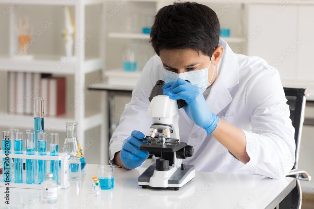 Health care researchers working in life science laboratory. Male research scientist and supervisor preparing and analyzing microscope slides in research lab. Invention of the coronavirus vaccine Health care researchers working in life science laboratory. Male research scientist and supervisor preparing and analyzing microscope slides in research lab. Invention of the coronavirus vaccine
