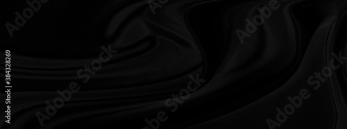 Black gray satin dark fabric texture luxurious shiny that is abstract silk cloth panorama background with patterns soft waves blur beautiful.