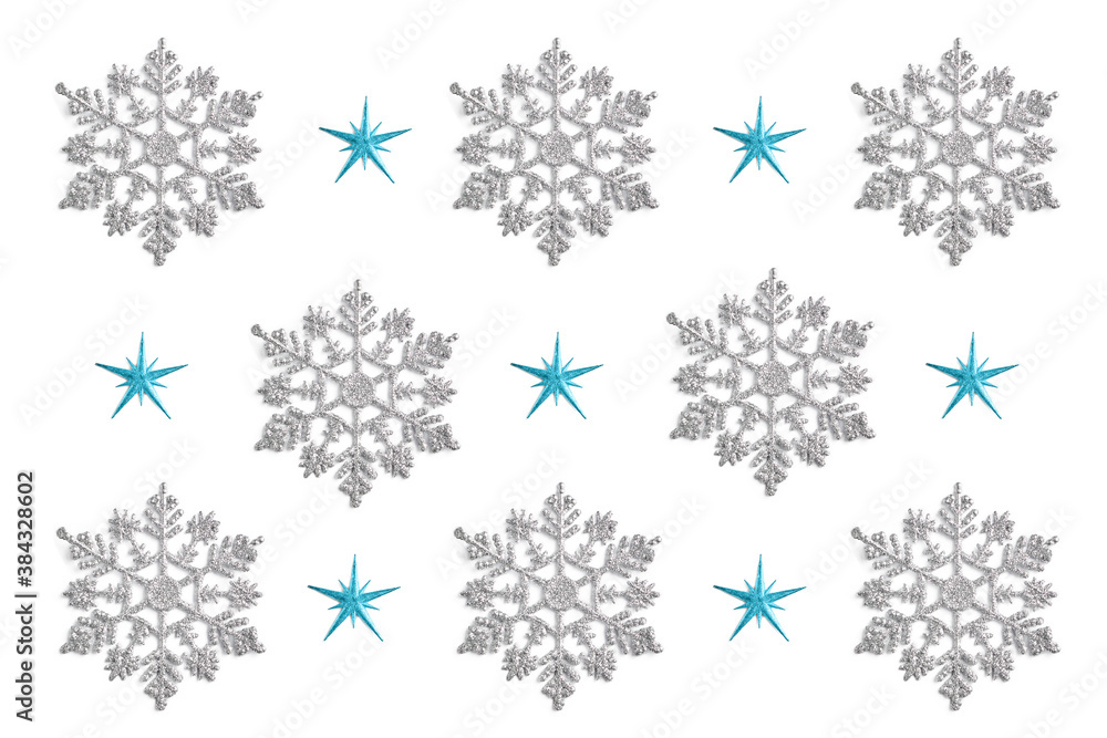 pattern of Christmas decor in the form of silver snowflakes on a white background. new year concept, top view pattern of Christmas decor in the form of silver snowflakes on a white background. new year concept, top view