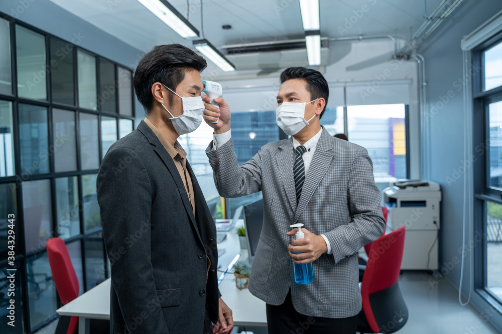 Business people with face mask protect from Coronavirus or COVID-19,Body temperature check,Prevent virus Concepts in preventing contagious diseases. Business people with face mask protect from Coronavirus or COVID-19,Body temperature check,Prevent virus Concepts in preventing contagious diseases.
