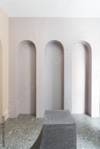 Studio template and white rectangle shape terrazzo pedestal with arc wall background in natural light scene for product advertising. photo