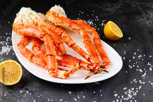 Crab legs in a plate on a dark background. Ready to eat.
