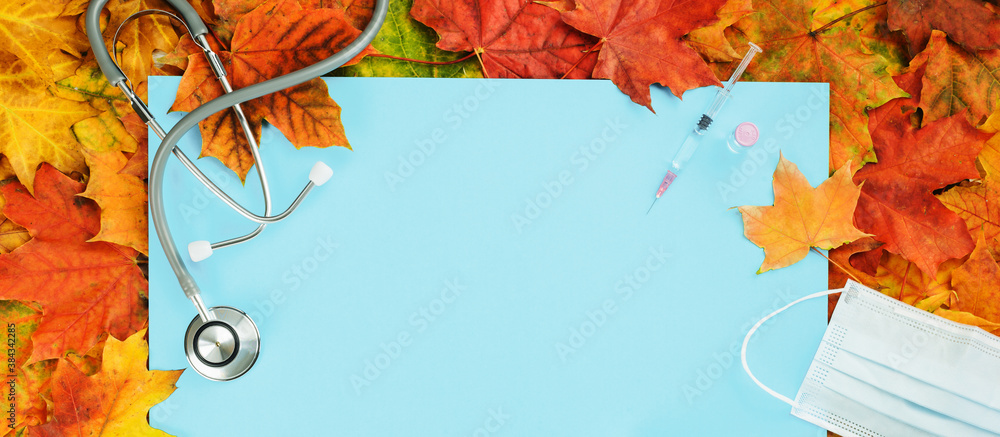 Flu and cold season frame on blue with fall leaves. Flu season or second wave. Face protective mask, sanitizer or soap and flu jab vial. Vaccine trial vaccination and immunization concept poster - obrazy, fototapety, plakaty 