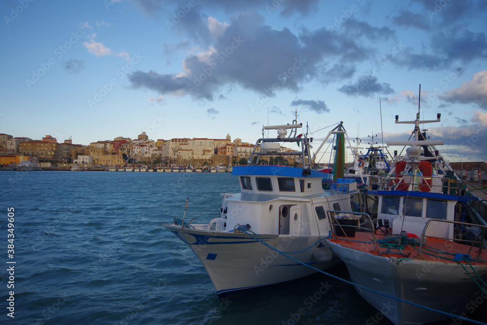 Termoli - Molise: In the foreground two fishing boats moored in the port, in the background the ancient village with its characteristic colored houses.