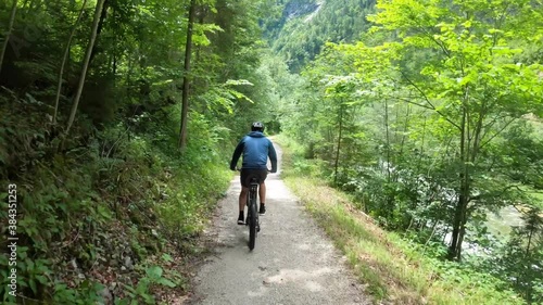 Mountain Biker MTB riding a trail through a lush forest, Austrian Alps, Ausseerland, Salzkammergut, Austria