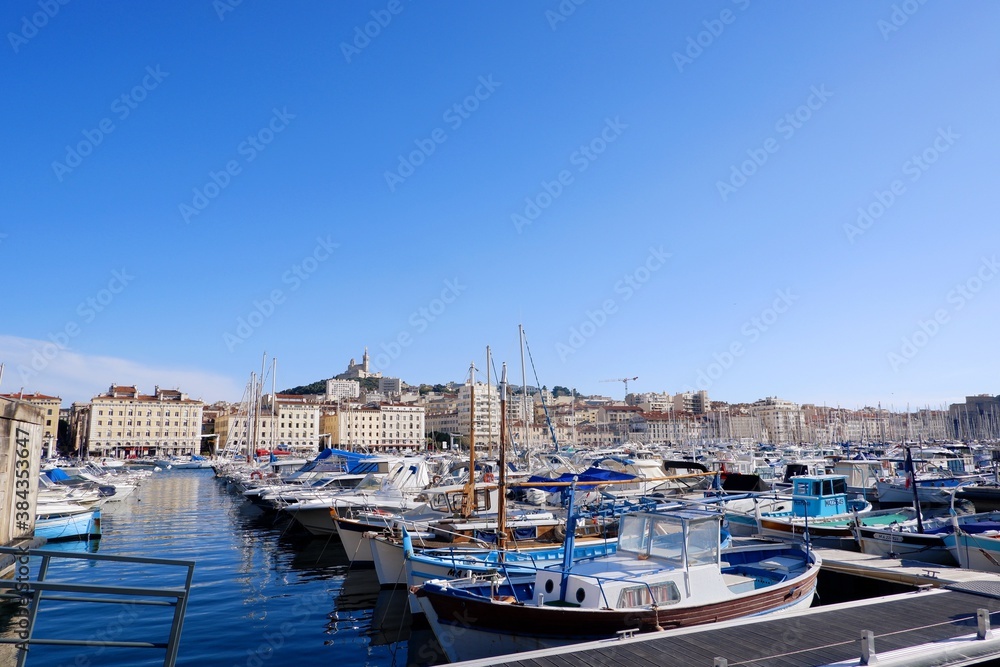 Marseille, France - May 28, 2019 : View of yatchs in Marseille Vieux Port and Notre Dame de la Garde church on the Mediterranean coast and the largest port for commerce