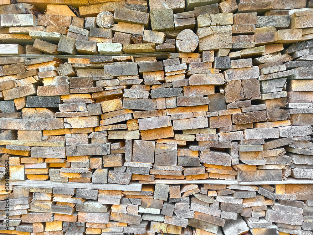 Background from multi-colored ends of wooden bars of different sizes and shapes. Wood texture. Woodpile in the village. Harvesting firewood Background from multi-colored ends of wooden bars of different sizes and shapes. Wood texture. Woodpile in the village. Harvesting firewood