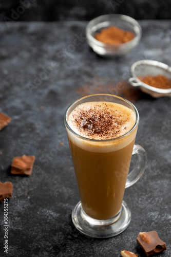 Fototapeta Naklejka Na Ścianę i Meble -  Hot chocolate drink. Tall glass up of fresh coffee latte with whipped cream, isolated on dark background
