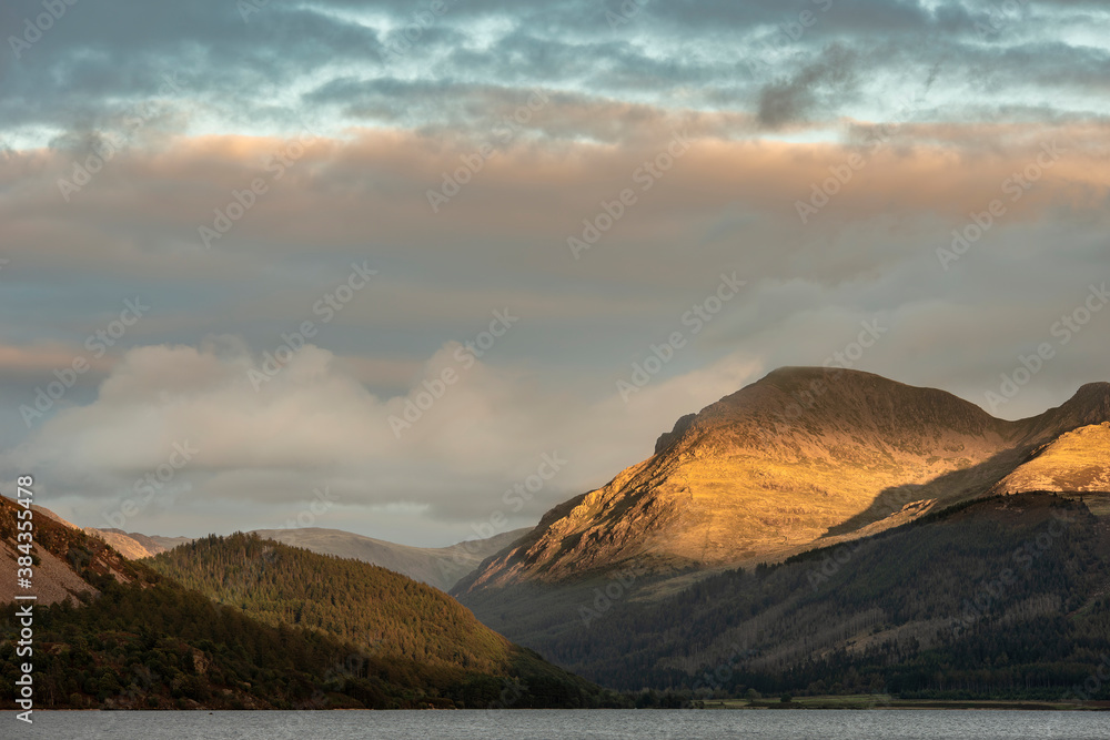 Stunning landscape image looking across Ennerdale Water in the English Lake District towards the peaks of Scoat Fell and Pillar during a glorious Summer sunset