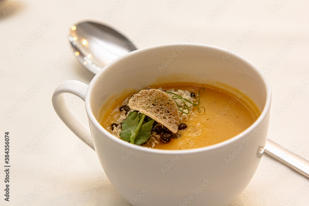 Pumpkin cream soup with a slice of truffle poured in a Cup Pumpkin cream soup with a slice of truffle poured in a Cup