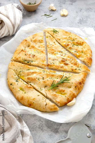 Freshly baked flat garlic bread, foccacia with olive oil and herbs.