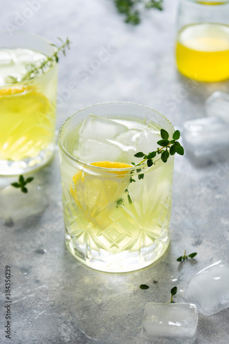 Refreshing yellow lemon glass of summer drink in glass. Soda lemonade drink with herb.