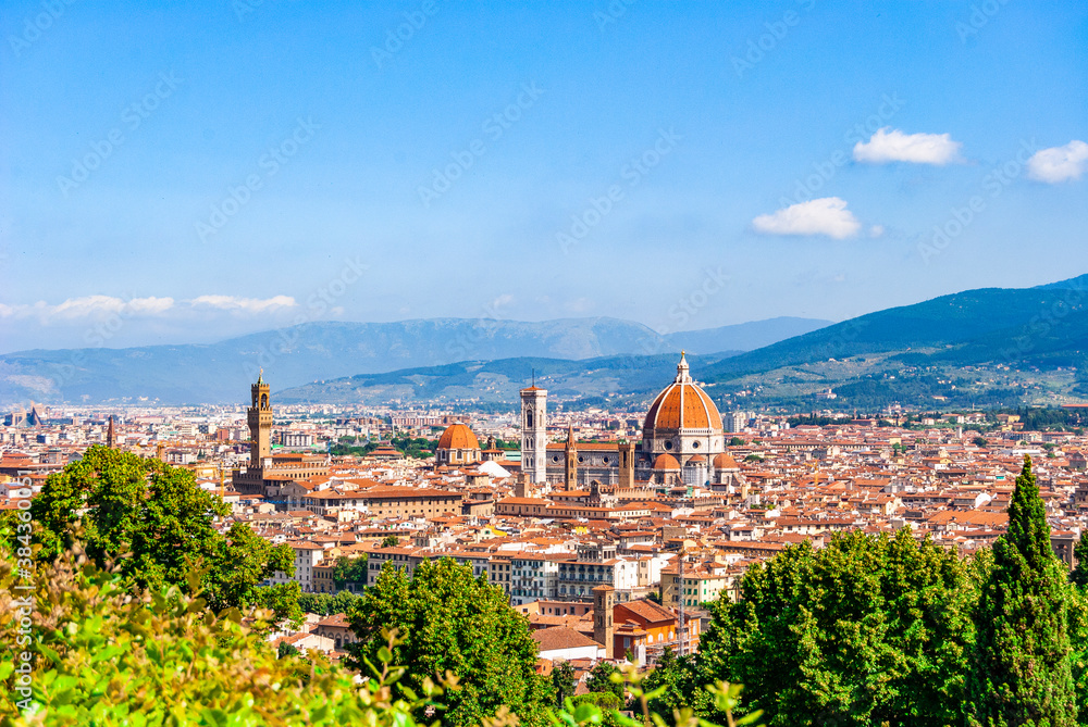Obraz premium Scenic view of Florence from the Basilica of San Miniato al Monte, near Piazzale Michelangelo. Blue sky and vegetation; Tuscany region, Italy.
