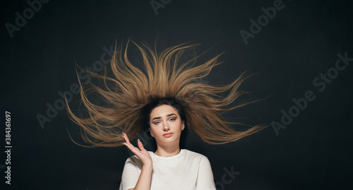 young confused woman with long hair, student on black studio background of black school board top view