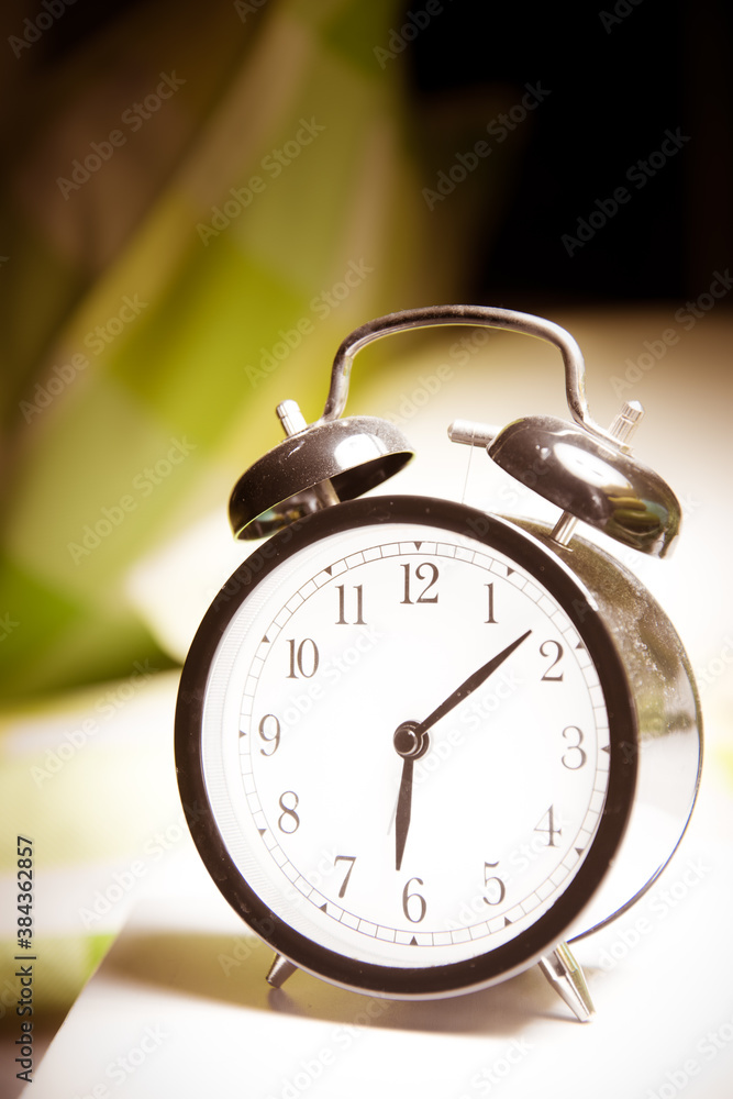 Naklejka premium Alarm clock on bed side table