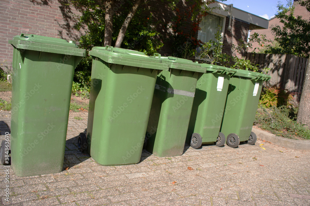 Green plastic containers in a row along the street for green waste in Arnhem, Netherlands Green plastic containers in a row along the street for green waste in Arnhem, Netherlands