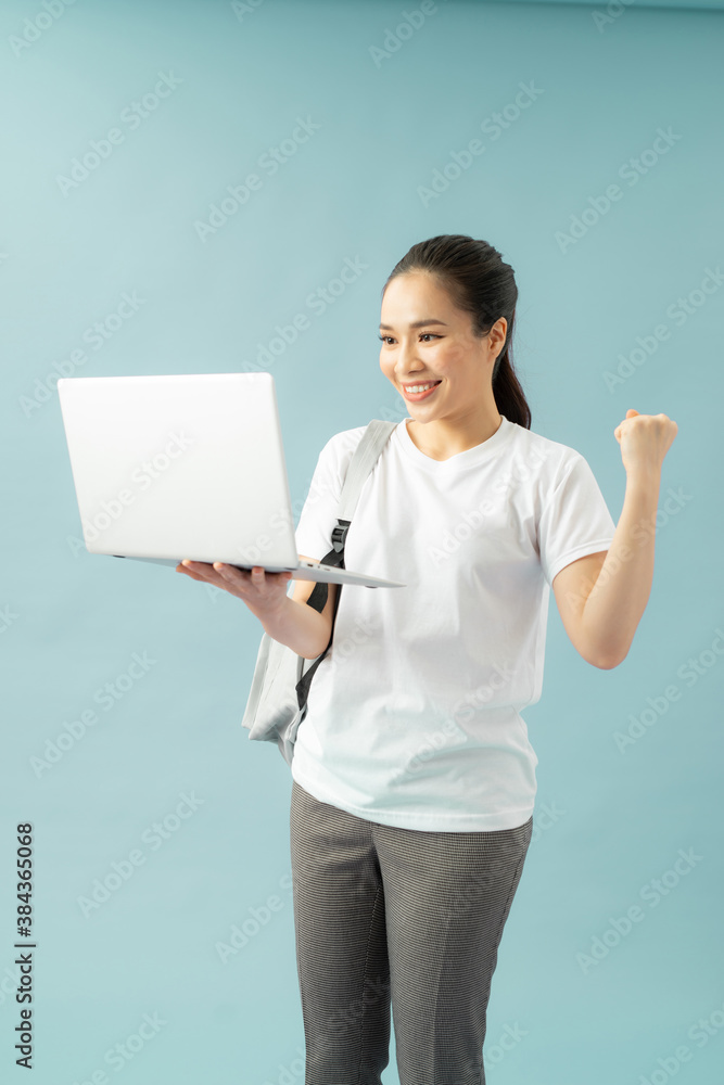 Smiling teenager with laptop on blue background Smiling teenager with laptop on blue background