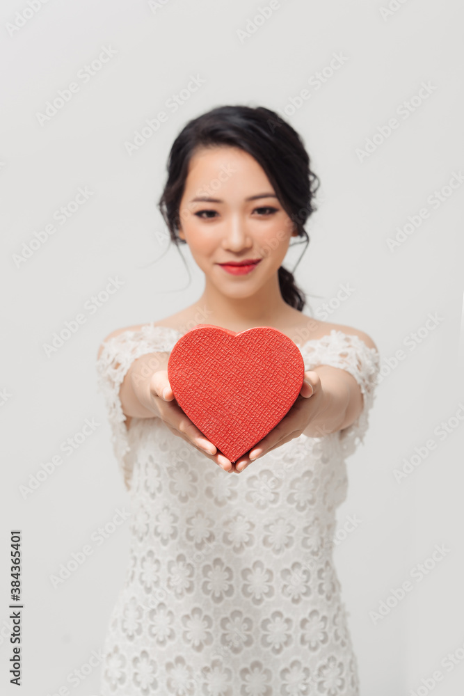 Portrait of young beautiful Asian girl holding love gift box over white background. Portrait of young beautiful Asian girl holding love gift box over white background.
