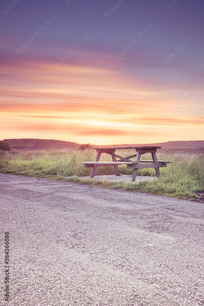 Wooden bench under stunning sunset clouds