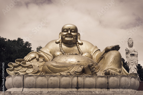 Rich and fat Buddha sitting on stone, religion
