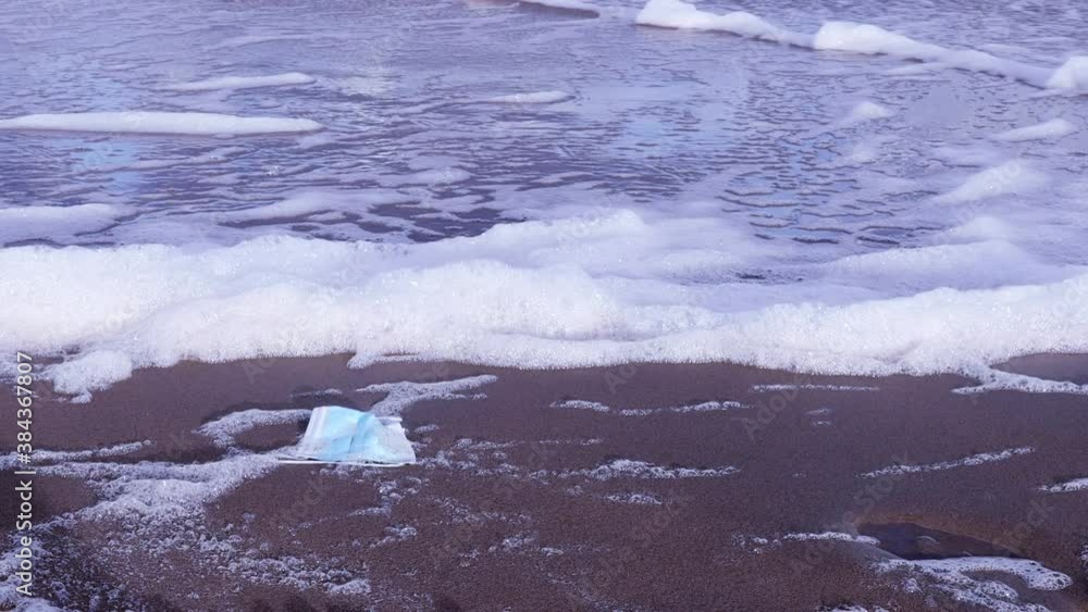 Used Medical Face Masks On Sandy Sea Beach Environmental And Ocean Plastic Waste Pollution During COVID-19 Coronavirus Pandemic. Used Medical Face Masks On Sandy Sea Beach Environmental And Ocean Plastic Waste Pollution During COVID-19 Coronavirus Pandemic.