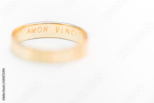 Golden wedding ring isolated on white background - amor vincit omnia engraved
