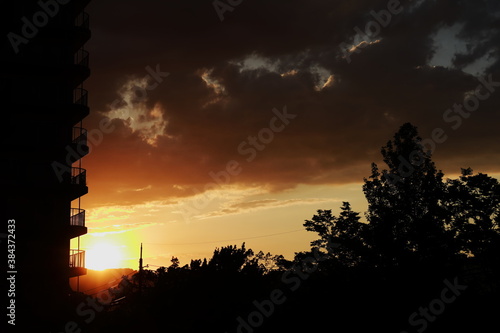 オレンジに染まった夕焼けとマンションのベランダのシルエット