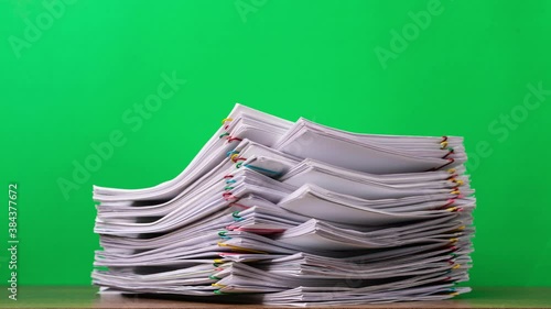 4K Stop of motion close-up stack overload document report paper with paperclip place increase on green background, business and education concept footage paperless used. 