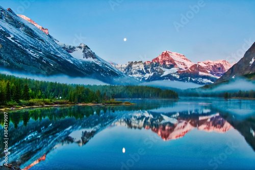 Mirrored Sunrise Lake Showing Moon and Glacier National Park Mountains