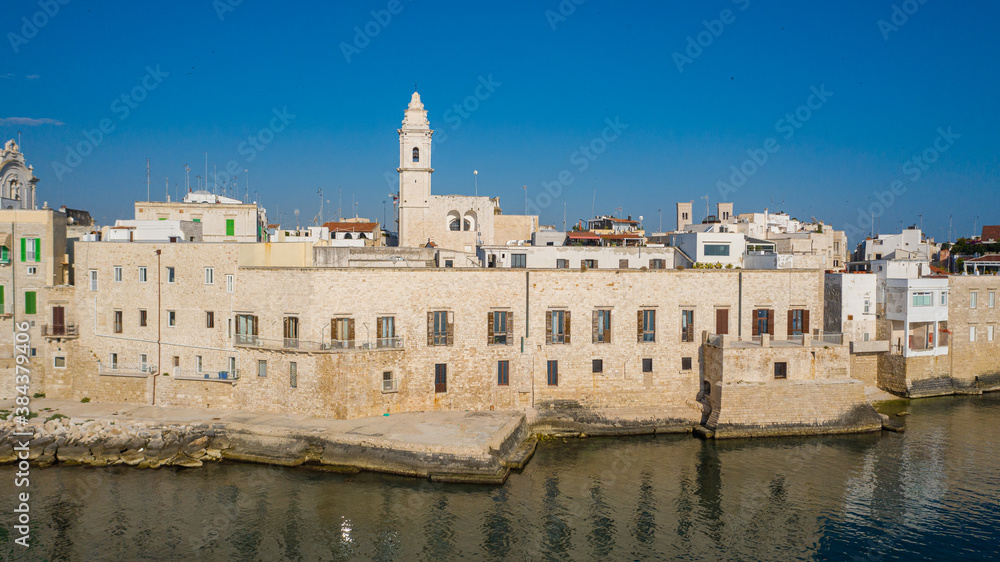 Beautiful panoramic aerial view photo from flying drone on Molfetta waterfront and the old town from a great height.Port with ships and yachtsand the Molfetta new city at sunrise.Apulia,Italy (Series)