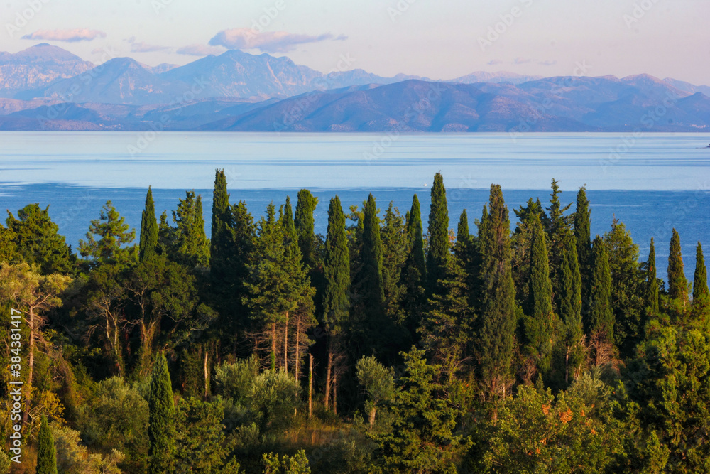 panoramic view of corfu island, mountains and sea with cypress and olive trees	