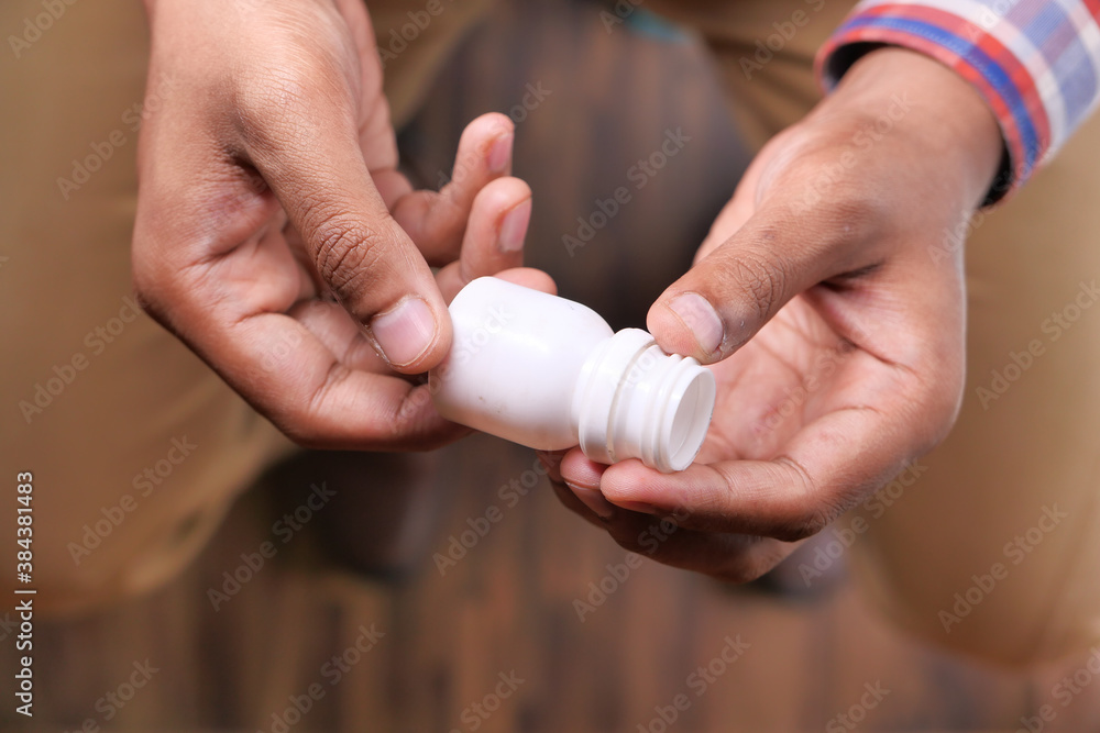 Close up of person hand holding pill container Close up of person hand holding pill container