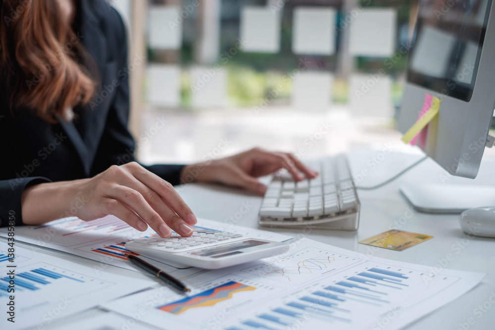 Business accounting, Businessman using calculator with budget document, computer laptop and in office, Savings, finances, and economy concept. Business accounting, Businessman using calculator with budget document, computer laptop and in office, Savings, finances, and economy concept.