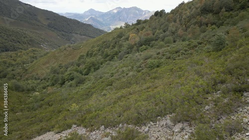 Aerial Descent to a Fall Forest from the bottom of a Mountain. Scenery shot. Asturias, Spain.