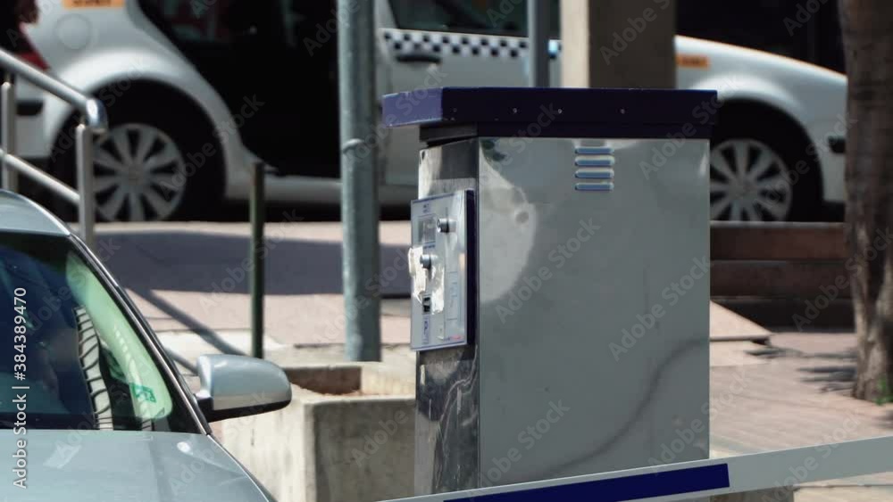 Skopje, Macedonia - 03 Jul, 2019: People are taking a parking lot ticket at an automated pay machine in parking lot Skopje, Macedonia - 03 Jul, 2019: People are taking a parking lot ticket at an automated pay machine in parking lot