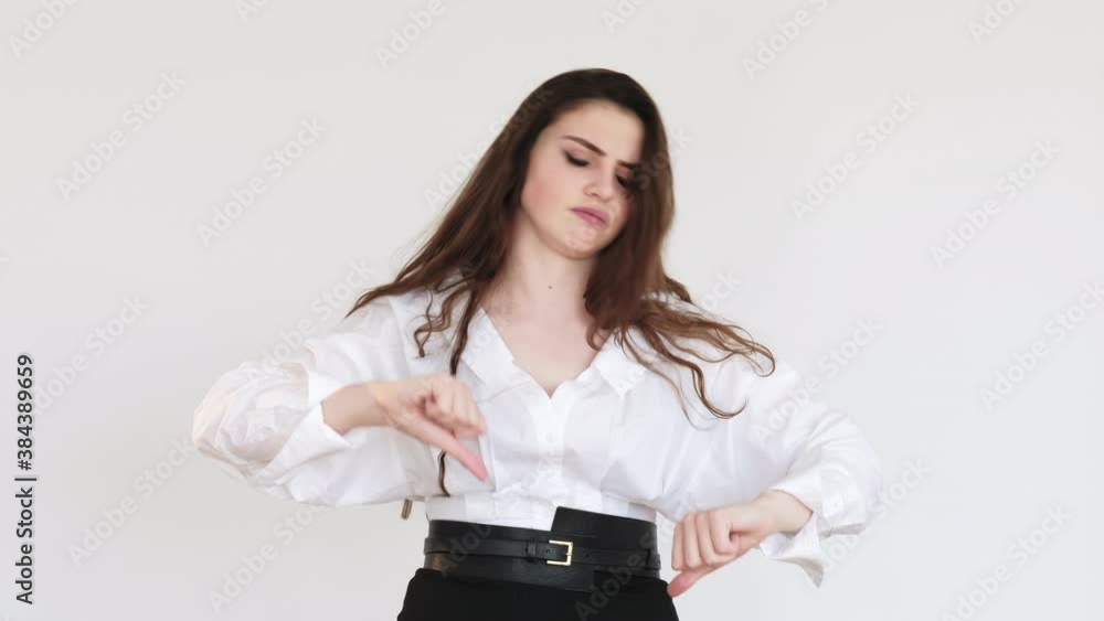 Dislike gesture. Bad idea. Skeptic business woman in white shirt rejecting with thumbs down stop sign isolated on light copy space background. No signal. Wrong choice. Dislike gesture. Bad idea. Skeptic business woman in white shirt rejecting with thumbs down stop sign isolated on light copy space background. No signal. Wrong choice.