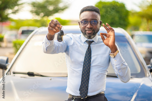 close up image of handsome african man, with key- automobile concept  © AMO