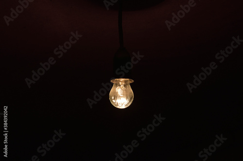 A burning incandescent lamp in a dark basement
