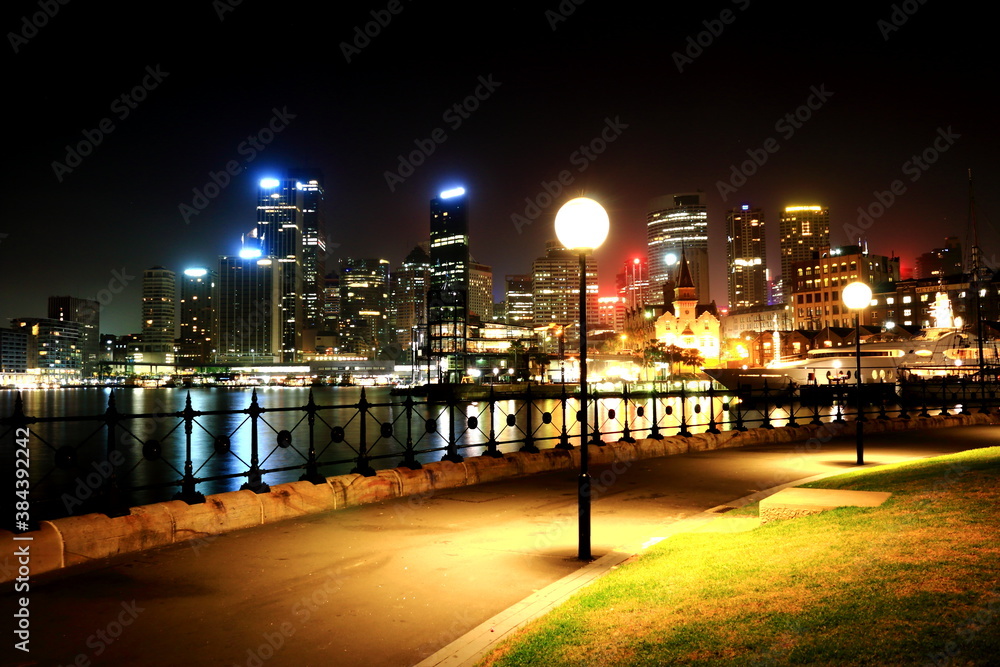 Fototapeta premium Night View of Sydney Promenade. Skyscrapers are seen across the water of Sydney Harbour.