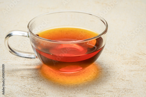 rooibos red tea - a glass cup of a hot drink, tea made from the South African red bush, naturally caffeine free