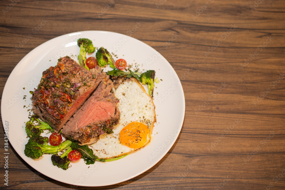 Roasted and seasoned meat with accompaniment of fried egg, brocolis, onion and tomato. Roasted and seasoned meat with accompaniment of fried egg, brocolis, onion and tomato.