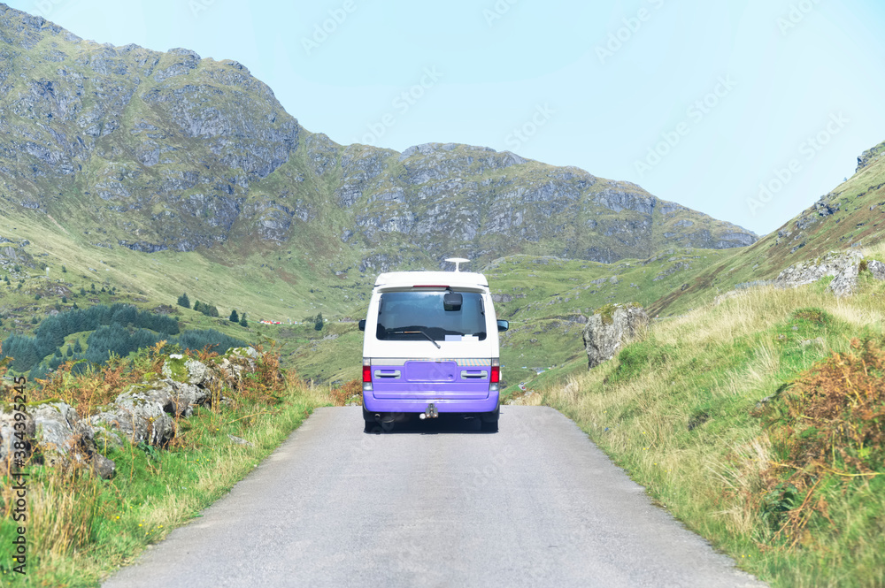 Purple campervan in remote mountain road trip