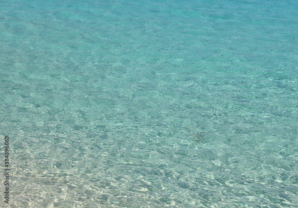 A photograph of vibrant blue clear water. Tropical background texture, travel concept