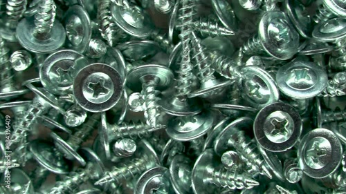 Stainless steel bolts. Metallic texture background. Screws and cogs. Tools for fixing and repairing. Background of the bolts. Galvanized metal fasteners. Close up. The view from the top.