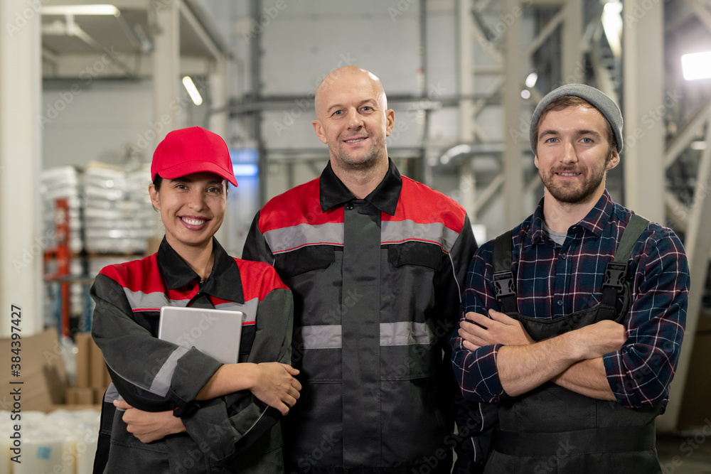 Group of successful and cheerful male and female engineers of large factory Group of successful and cheerful male and female engineers of large factory