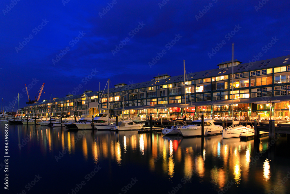 Walsh bay residential property buildings with yachts at night. Upscale, luxury waterfront Sydney property