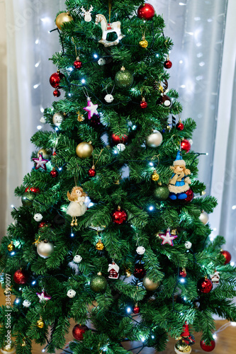 Close-up of a festively decorated Christmas tree with toys  balls and garlands.