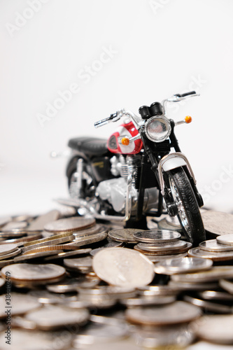 Modern classic motorcycle model on many of coins background, Finance concept. photo